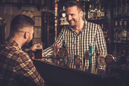 Man chatting with a bartender in a pubの写真素材