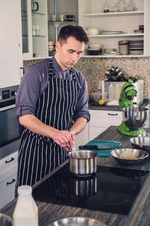 Chef cook working on a modern kitchen at homeの写真素材