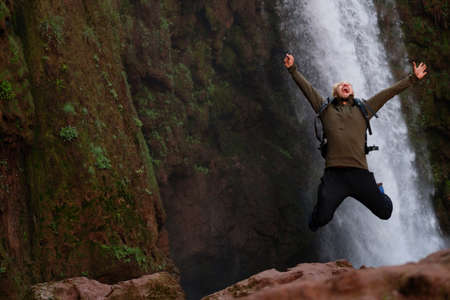 Happy adventurer jumping near Ouzoud waterfall in Moroccoの写真素材