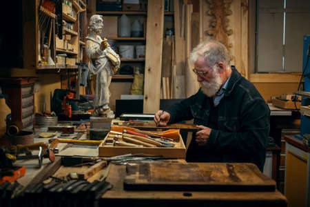Senior wood carving professional during workの写真素材