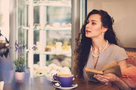 Elegant young lady alone in a cafeの写真素材