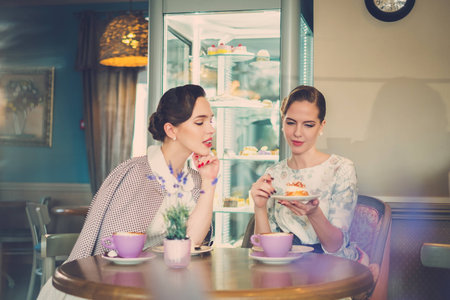 Two elegant young ladies in a cafeの写真素材