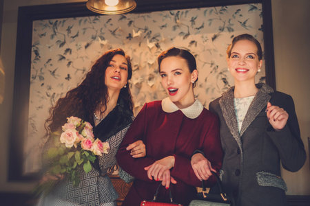 Three elegant young ladies ready for a partyの写真素材