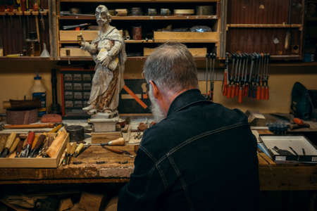 Senior wood carving professional during workの写真素材