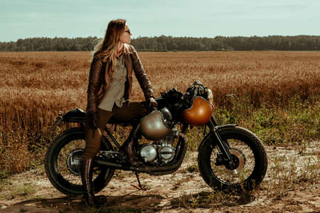 Woman rider with his vintage custom made cafe racerの写真素材