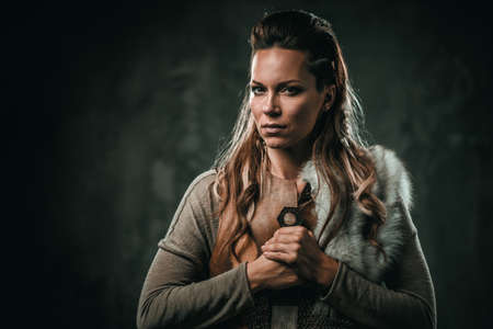 Viking woman with cold weapon in a traditional warrior clothesの写真素材