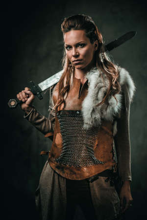Viking woman with cold weapon in a traditional warrior clothesの写真素材