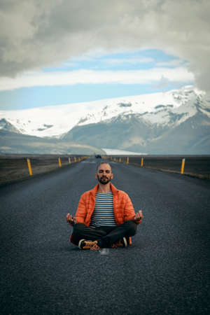 Travel hitchhiker man meditating on a roadの写真素材