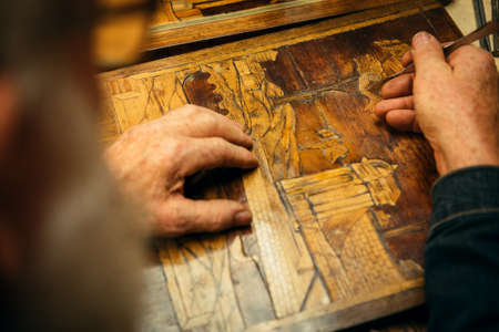 Senior wood carving professional during workの写真素材