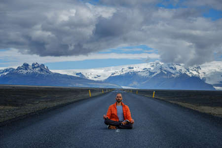 Travel hitchhiker man meditating on a roadの写真素材