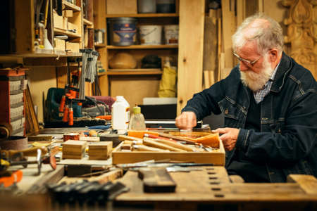 Senior wood carving professional during workの写真素材