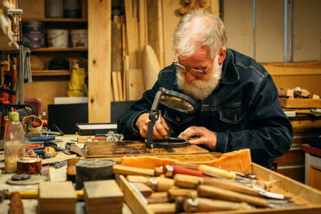 Senior wood carving professional during workの写真素材