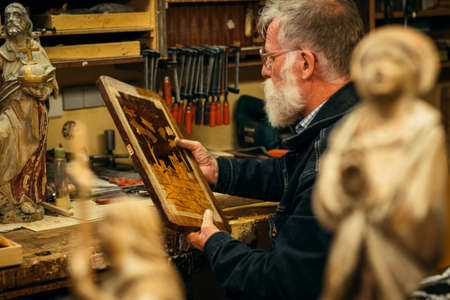 Senior wood carving professional during workの写真素材