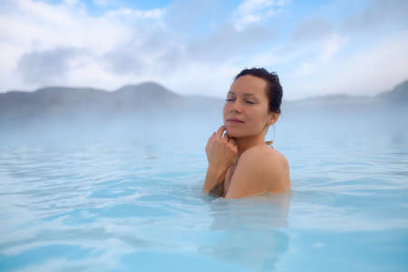 Woman enjoys spa in geothermal hot springの写真素材