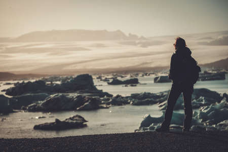 Woman explorer lookig at Jokulsarlon lagoon, Iceland.