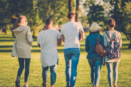 Multi-ethnic group of friends chatting in a park.の写真素材