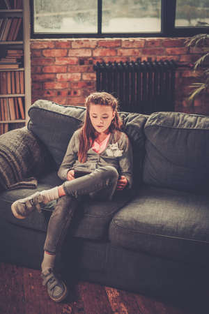 Little girl with tablet pc at home.の写真素材