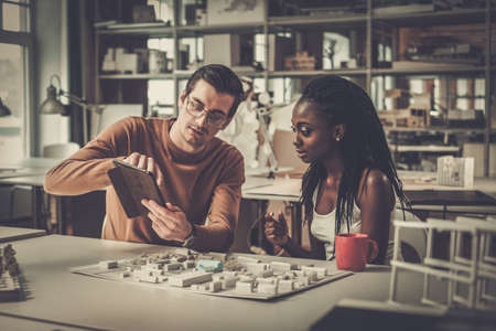 Multiracial couple working in design and engineering architecture office.の写真素材