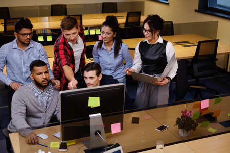 Young colleagues discussing ideas in coworking office.