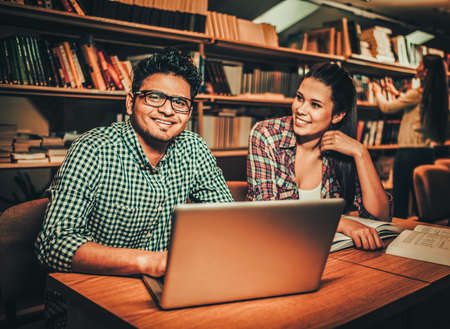 Multinational couple of students studying in the university libraryの写真素材
