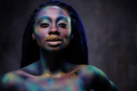 African woman with colourful powder on her face and body.の写真素材