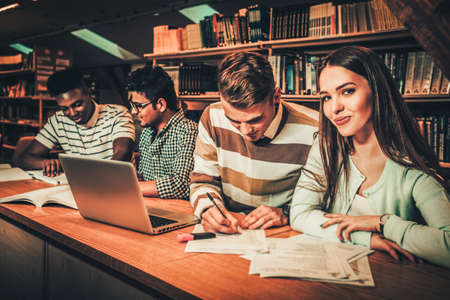 Multinational group of students studying in the university library.