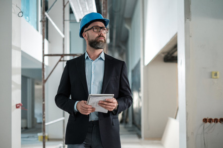 Middle-aged engineer in hardhat in factoryの写真素材
