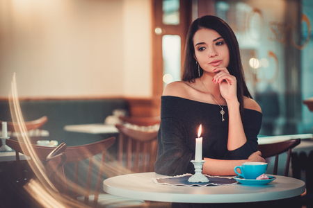 Beautiful woman sitting at the restaurantの写真素材