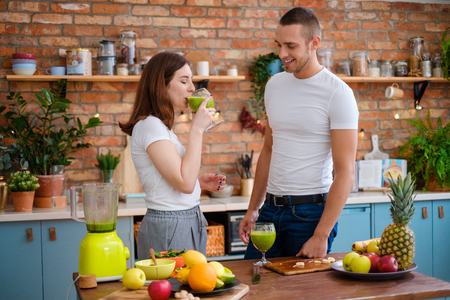 Young couple making smoothie in kitchenの写真素材