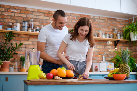 Young couple making smoothie in kitchenの写真素材