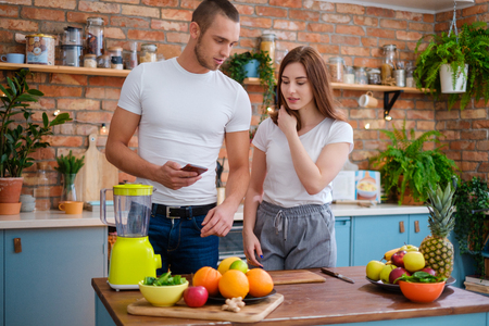 Young couple making smoothie in kitchenの写真素材