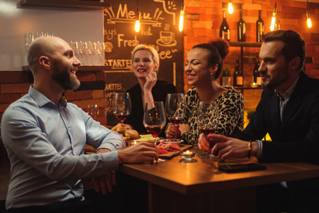 Group of friends having fun talk behind bar counter in a cafeの写真素材