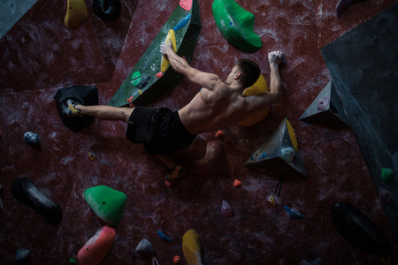 Athletic man practising in a bouldering gym.の写真素材