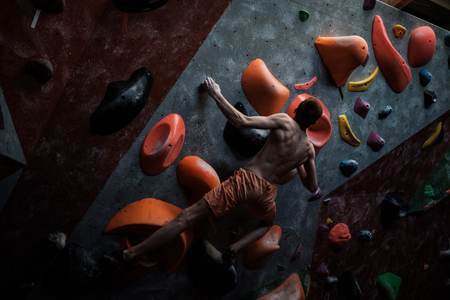 Athletic man practising in a bouldering gym.の写真素材