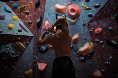 Athletic man practising in a bouldering gym.の写真素材