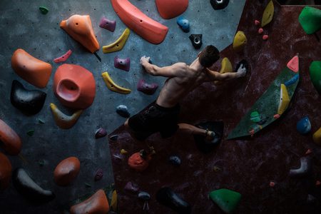 Athletic man practising in a bouldering gym.の写真素材