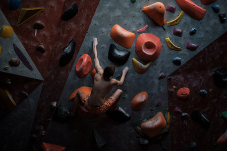 Athletic man practising in a bouldering gym.の写真素材