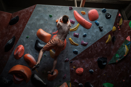 Athletic man practicing in a bouldering gym