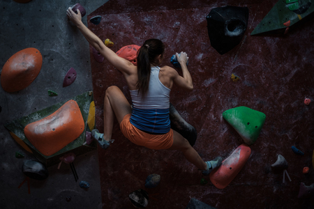 Athletic woman practicing in a bouldering gymの写真素材