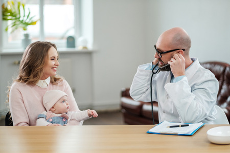 Mother with baby visiting pediatricianの写真素材