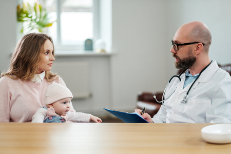 Mother with baby visiting pediatricianの写真素材