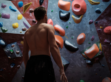 Athletic man stretching before climbing in a bouldering gymの写真素材