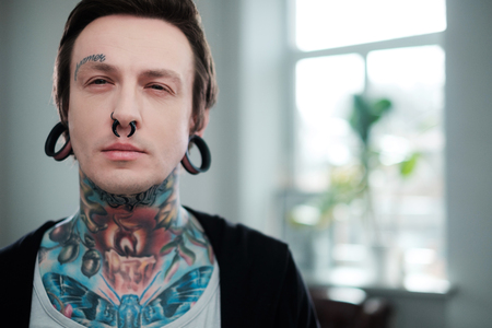 Portrait of alternative model with earplugs and tattooの写真素材