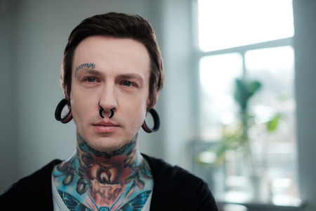 Portrait of alternative model with earplugs and tattoo