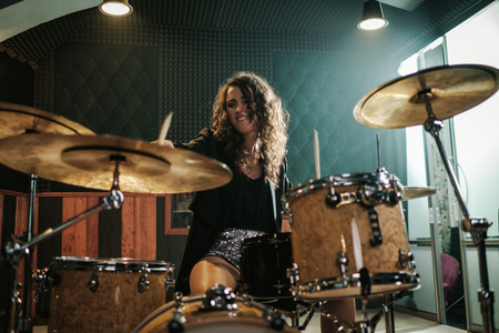 Woman playing drums during music band rehearsalの写真素材