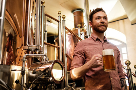 Man tasting fresh beer in a brewery.