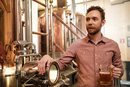 Man tasting fresh beer in a brewery.