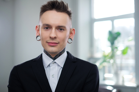 Portrait of alternative model with earplugs and tattooの写真素材
