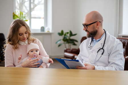 Mother with baby visiting pediatricianの写真素材