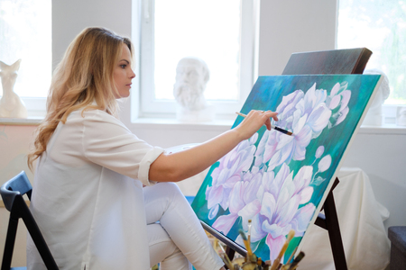 Creative painter paints a colorful picture in her studio.の写真素材